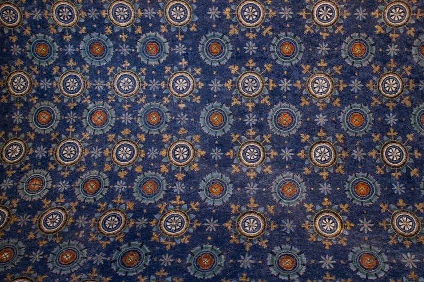 Ravenna, mosaico della volta del mausoleo di Galla Placidia, con fiori rossi e bianchi raggiati di oro.