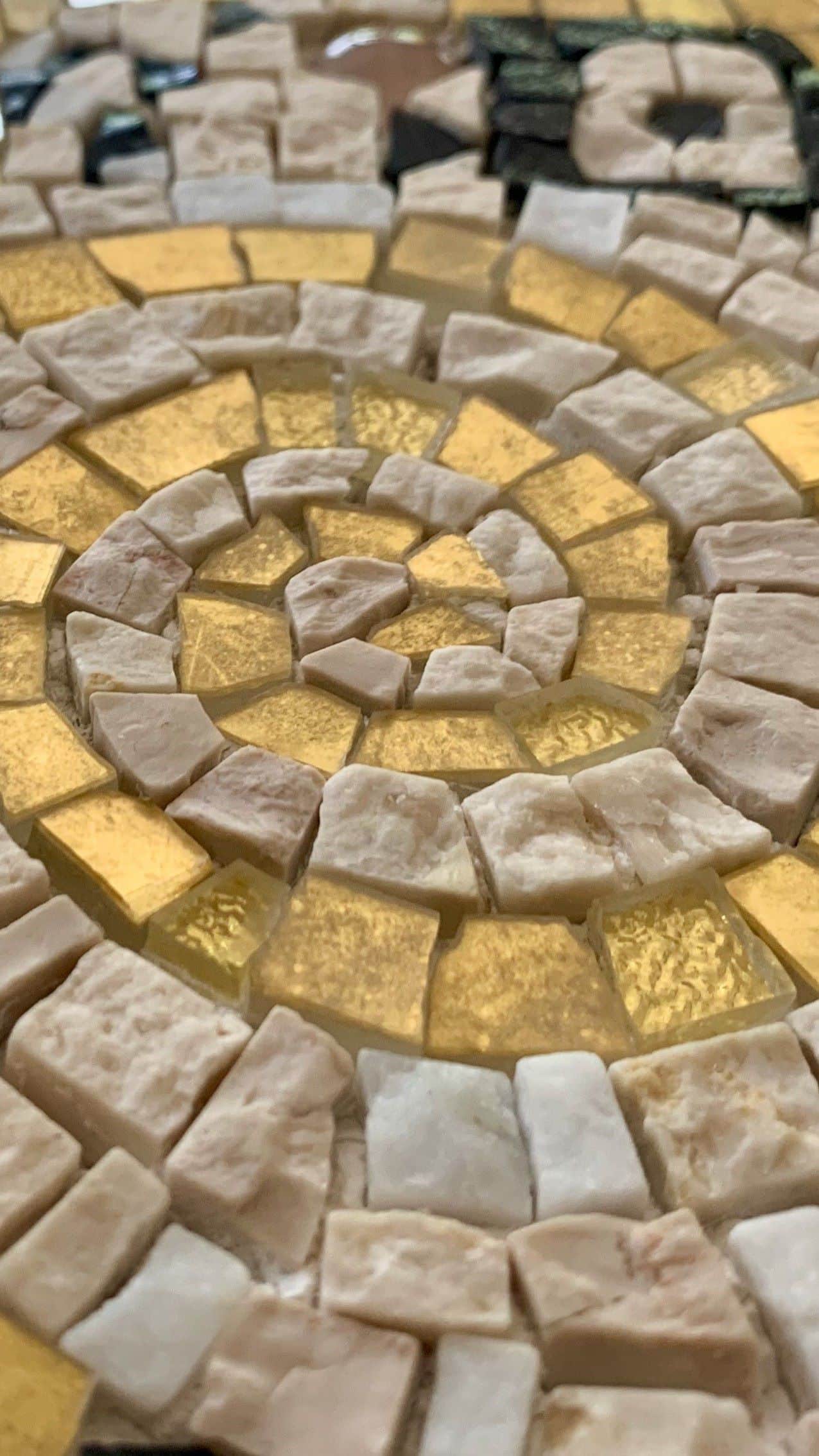Dettaglio di un mosaico di Pixel Mosaici con una voluta d'oro.