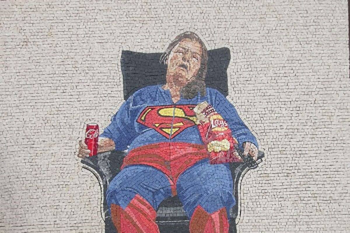 Mosaico con una donna sulla poltrona mentre fa un sonnellino, vestita da Superman