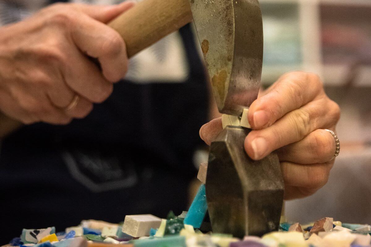 Foto di una tessera tagliata a mano con martellina e tagliolo
